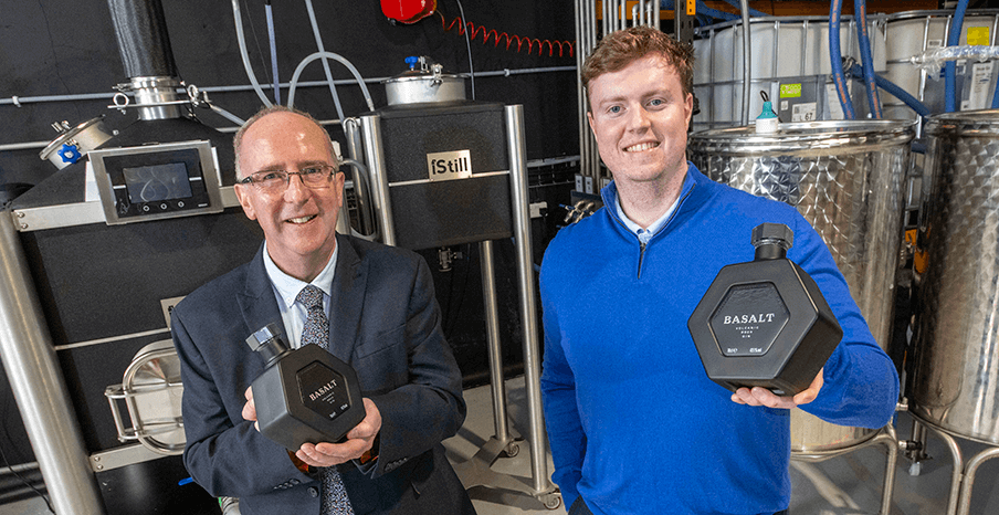 Two men standing in a distillery, they are both holding gin products